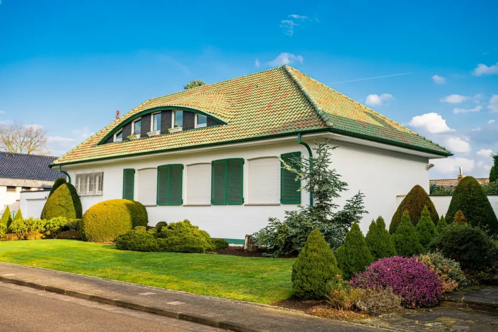 Weißes Einfamilienhaus mit Walmdach und gepflegtem Garten